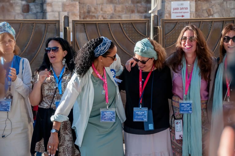 Women laughing and leaning on each other in the Western Wall plaza