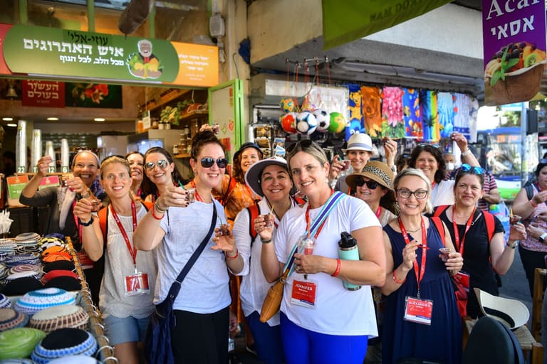 The group raising tasting glasses together in Machane Yehuda market