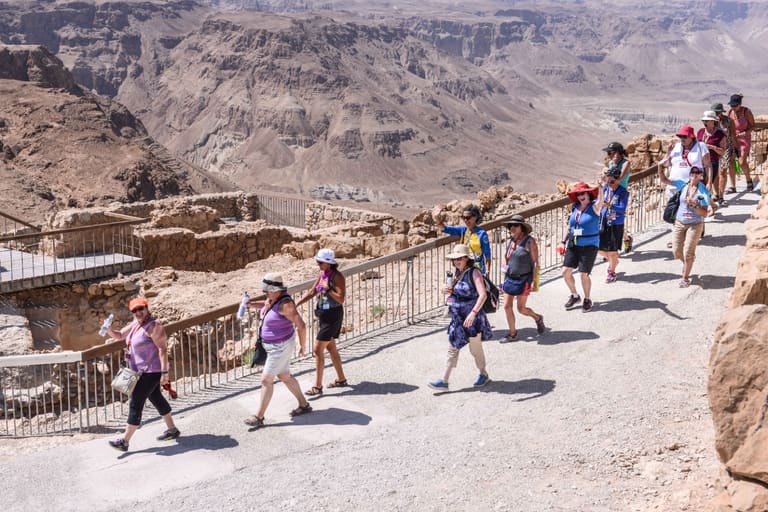 The group walking the ridge path at Masada above the desert