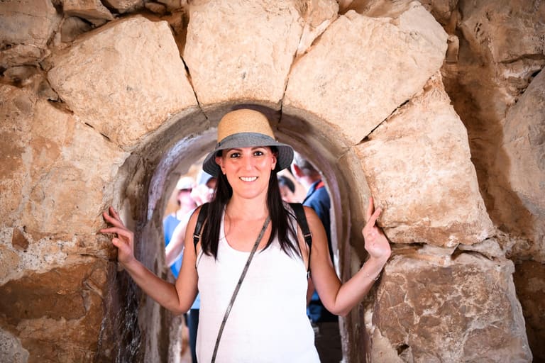 A woman standing in a stone gateway at Masada